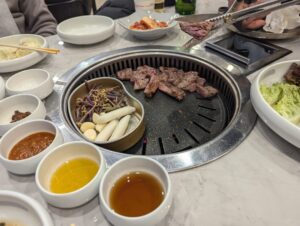 ソウルの焼肉店で肉を焼いている画像。はさみで肉を切っている。